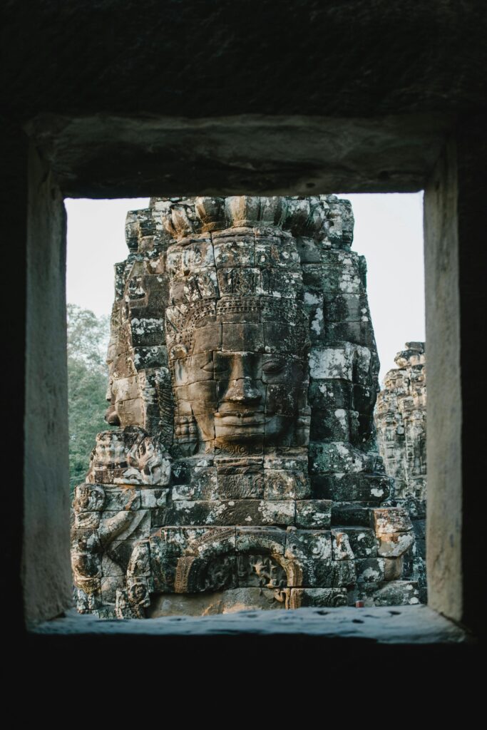 pexels-photo-5769455-5769455 Detailed view of a stone face sculpture at Bayon Temple, reflecting Khmer architecture and Buddhist art.
