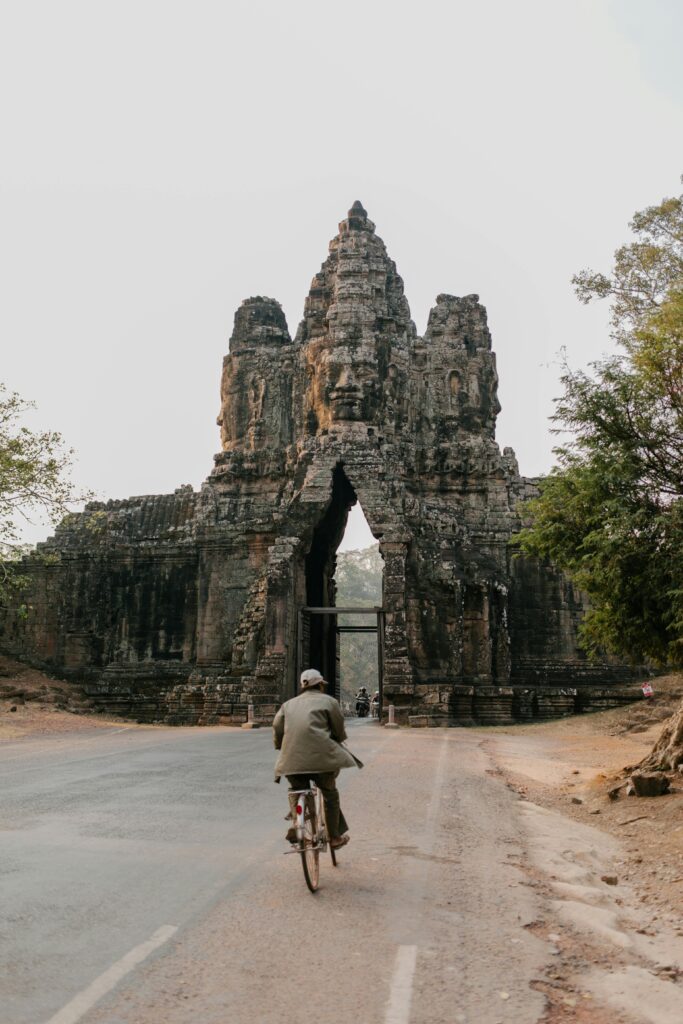 pexels-photo-5769456-5769456 A cyclist rides a bicycle through the iconic South Gate of Angkor Thom in Cambodia.