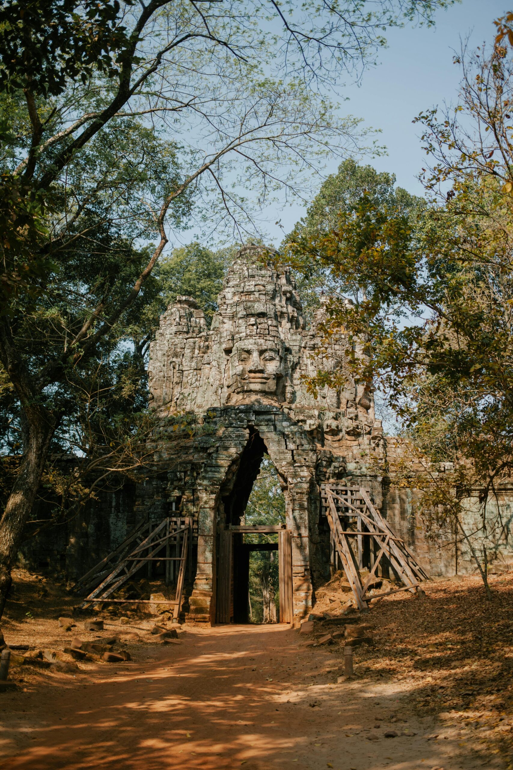 pexels-photo-5769403-5769403 Historic stone entrance gate of Angkor Thom in Cambodia surrounded by lush greenery.